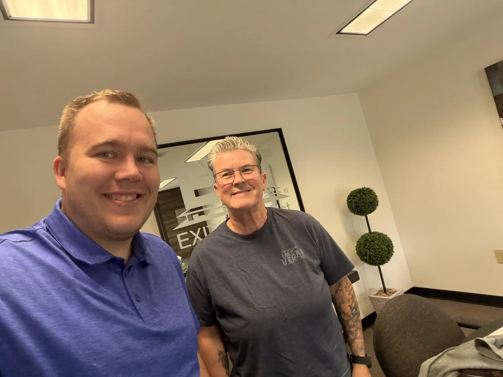 Hunter Klaassen smiling with a happy client at his Jackson, MI office